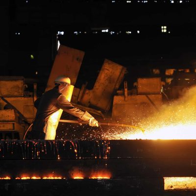 worker using torch cutter to cut through metal